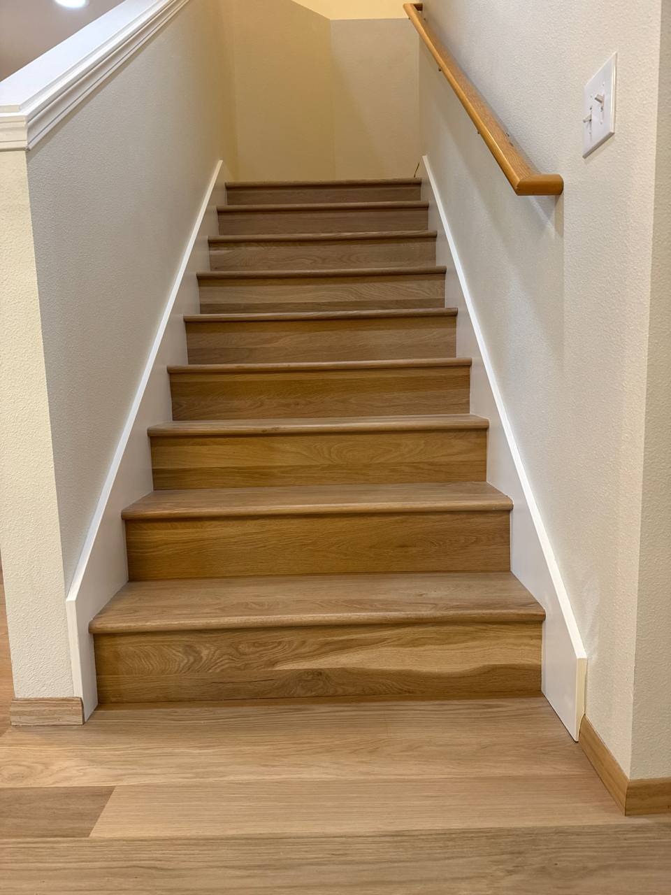 Custom hardwood oak staircase installation with white trim
